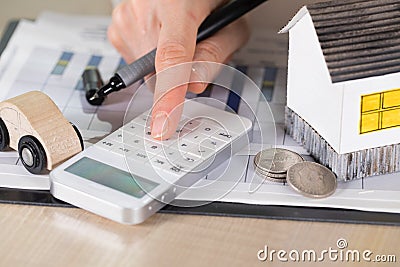 Young woman makes some calculations. Small paper house, coins, c Stock Photo