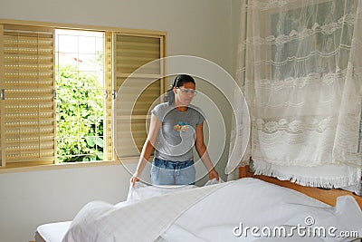 Young woman making bed Stock Photo