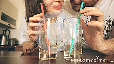 Young woman and man drinking juice with straws together. Healthy lifestyle or funny competition concepts Stock Photo