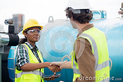 Young woman and man engineer doing agreement and handshake in the factory. Stock Photo