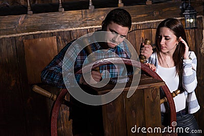 Young woman and man stand at the helm of the ship and look at th Stock Photo