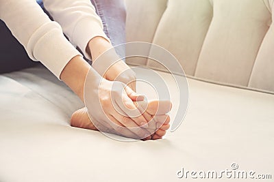 A young woman massaging her painful ankle Stock Photo