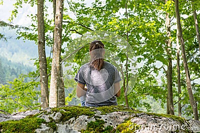 Young woman meditating on forest rock. Stock Photo