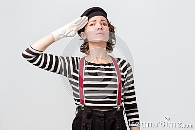 Young woman mime looking at camera and saluting Stock Photo