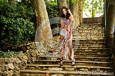 Young woman, model of fashion, in a garden stairs Stock Photo