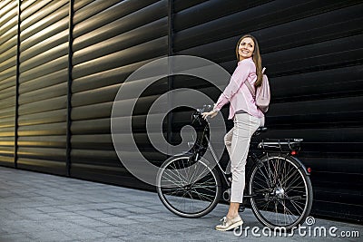 Young woman with modern city electric e-bike as clean sustainable urban transportation Stock Photo