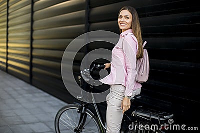 Young woman with modern city electric e-bike as clean sustainable urban transportation Stock Photo