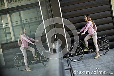 Young woman with modern city electric e-bike as clean sustainable urban transportation Stock Photo