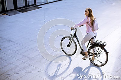 Young woman with modern city electric e-bike clean sustainable urban transportation Stock Photo