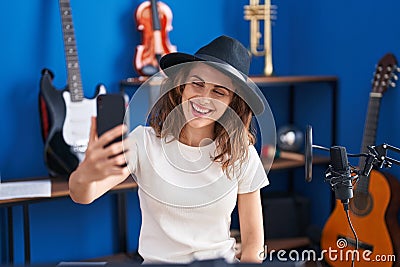 Young woman musician making selfie by smartphone at music studio Stock Photo