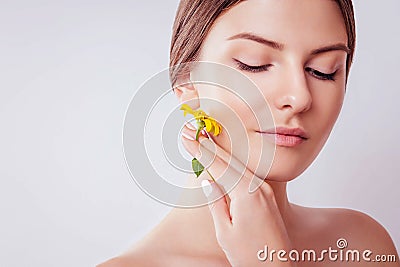 Young woman with natural makeup holding a flower. Organic cosmetics concept Stock Photo