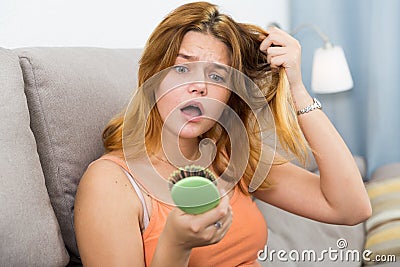 Young woman is nervous because her hair suffers from avitaminosis Stock Photo