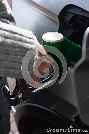 A young woman with a nice sweater, refuels in her vehicle. Image taken from a high angle Stock Photo
