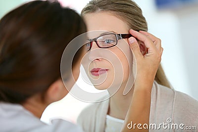 Young woman in optical store trying on eyeglasses Stock Photo