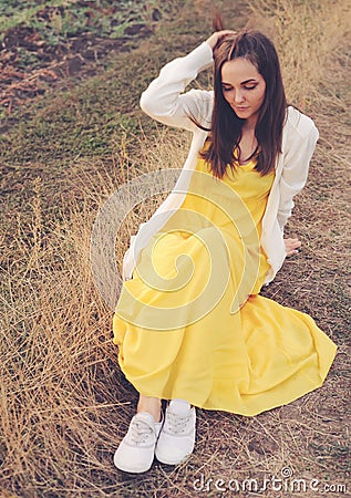 Young woman outdoor portrait sitting on a deadwood field. Stock Photo