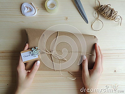 Young woman, owner of sewing small business wrapping an parcel for delivery. Gift wraping idea. Stock Photo