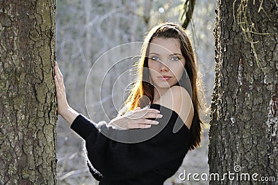 The young woman in park between trees Stock Photo