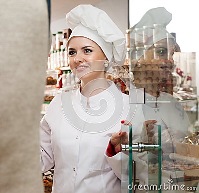 Young woman pastry chef greets visitors at the door Stock Photo