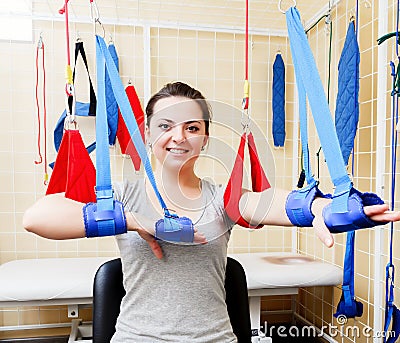 Young woman patient doing physical exercises in a rehabilitation study. Stock Photo