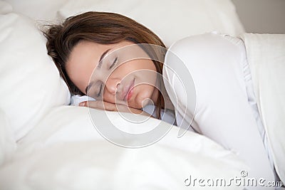 Healthy girl lying asleep on white sheets resting at home Stock Photo