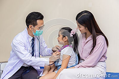 Young woman pediatrician performs a vaccination of a little girl. Looks at the doctor Stock Photo