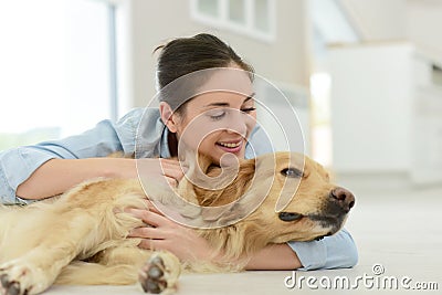 Young woman petting dog on the floor Stock Photo