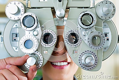 Young woman at phoropter for eye test Stock Photo