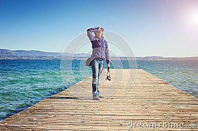 Young woman photographer beams morning sun bridge pier Sirmione lago di Garda Italy Stock Photo