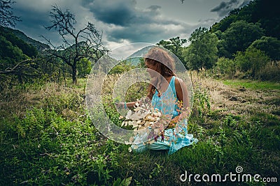 Young woman pick herbs and flowers on clean wild mountain meadow Stock Photo