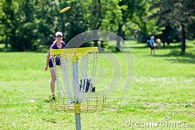 Young woman playing flying disc golf sport game in the park Editorial Stock Photo