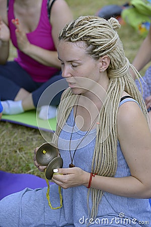 Young woman playing karatals, Tibetan temple bells, for meditation Editorial Stock Photo