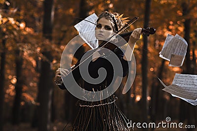 Young woman plays violin over the music flying notes Stock Photo