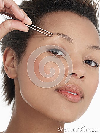 Young Woman plucking Eyebrow Stock Photo