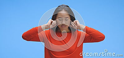 Young woman plugging hear ears with fingers Stock Photo