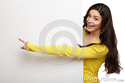 Young woman pointing her finger at blank board Stock Photo