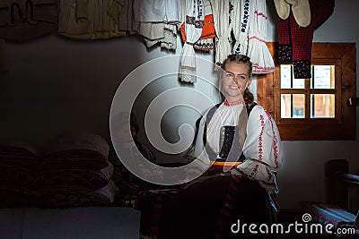 Young woman portrait inside traditional home with Romanian traditional costume Editorial Stock Photo