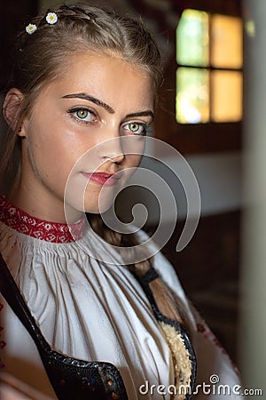 Young woman portrait inside traditional home with Romanian traditional costume Editorial Stock Photo