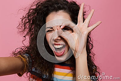 Young woman posing isolated over pink background make okay gesture. Stock Photo