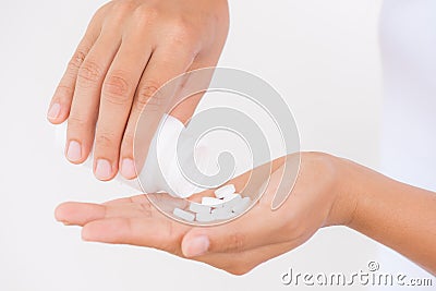 A young woman pours out medicine, capsule or pill into her hand. Stock Photo