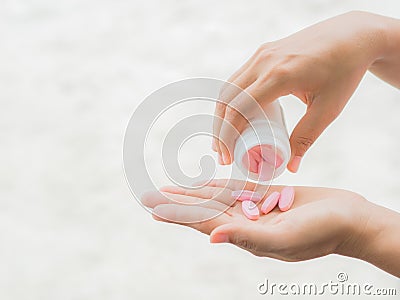 A young woman pours out medicine into her hand Stock Photo