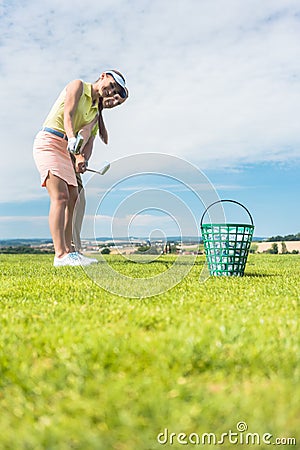 Young woman practicing the correct move during golf class with Stock Photo