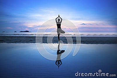 Young woman practicing yoga on beach at surrealistic sunset. Stock Photo