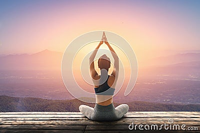 Young woman practicing yoga in the nature, Female happiness, Young woman is practicing yoga at mountain Stock Photo