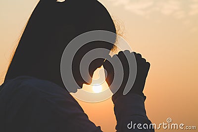 Young woman praying in the morning, Hands folded in prayer concept for faith, spirituality and religion Stock Photo