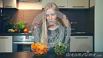 Young woman preferring salad to crisp. Stock Photo