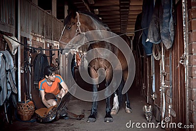 Young woman prepares the saddle Stock Photo