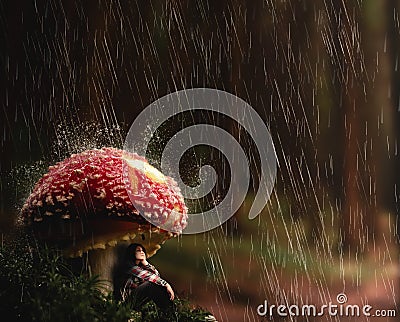 Young woman protect herself from rain under a mushroom.. Stock Photo