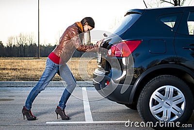 Young woman pushing car Stock Photo