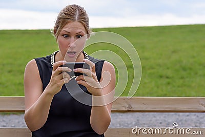 Young woman reacting in shock to an sms Stock Photo