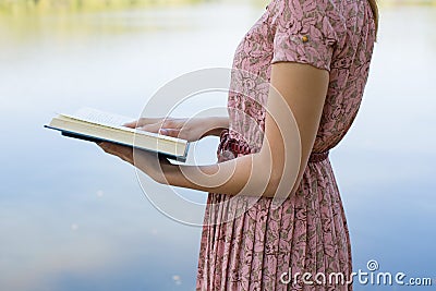Young woman reading bible in natural park Stock Photo